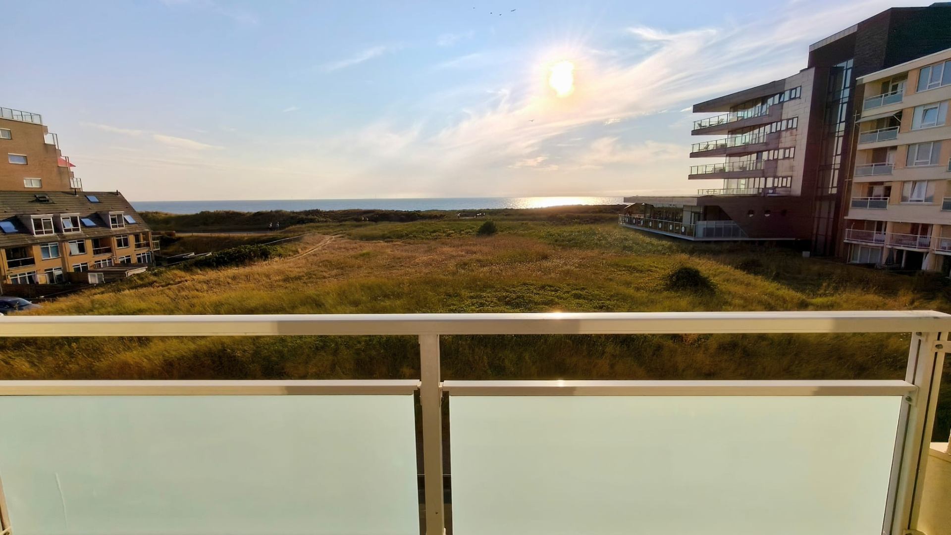 Uitzicht vanaf het balkon over de duinen naar zee