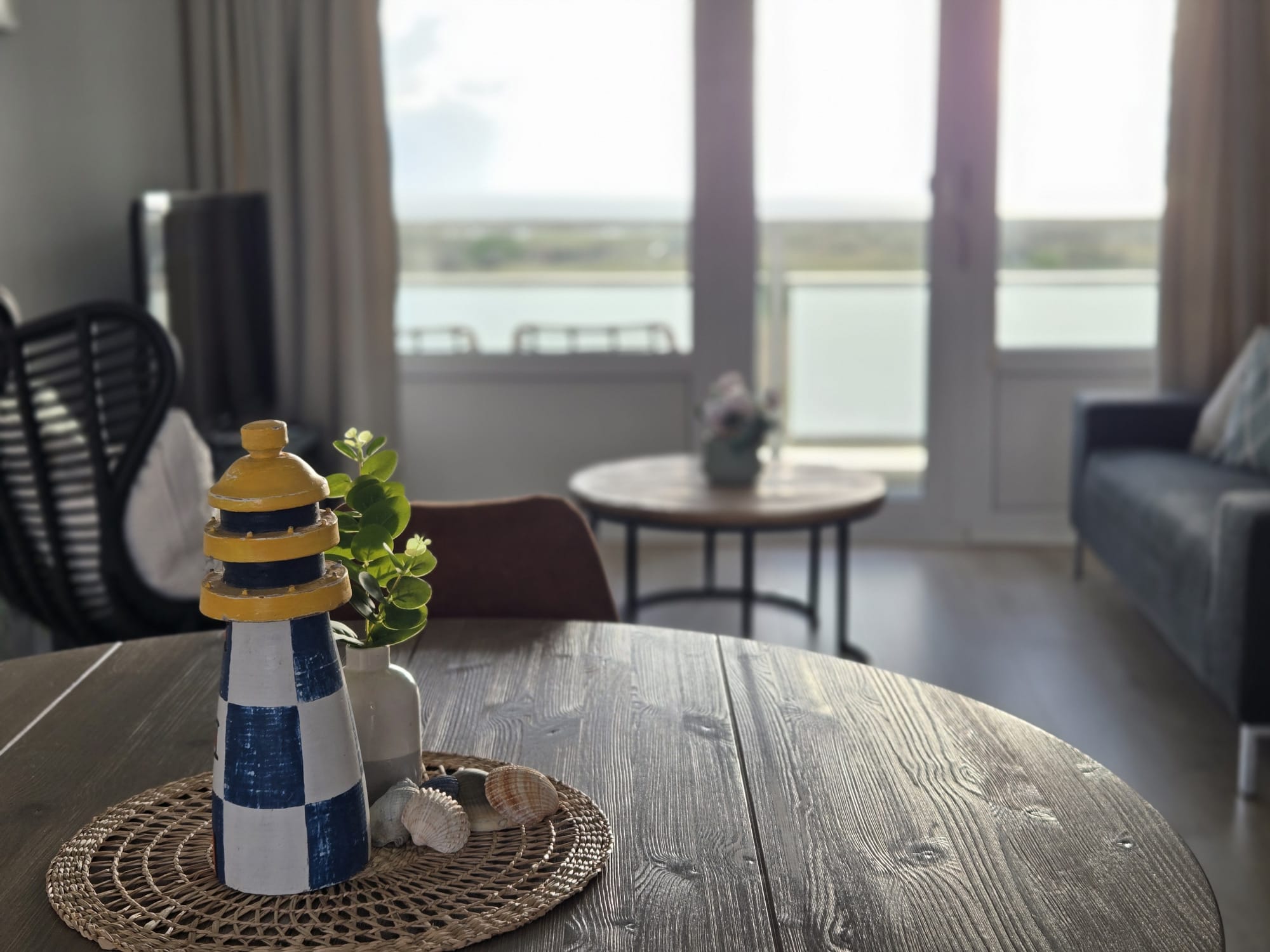 Eettafel met decoratieve vuurtoren en zeezicht