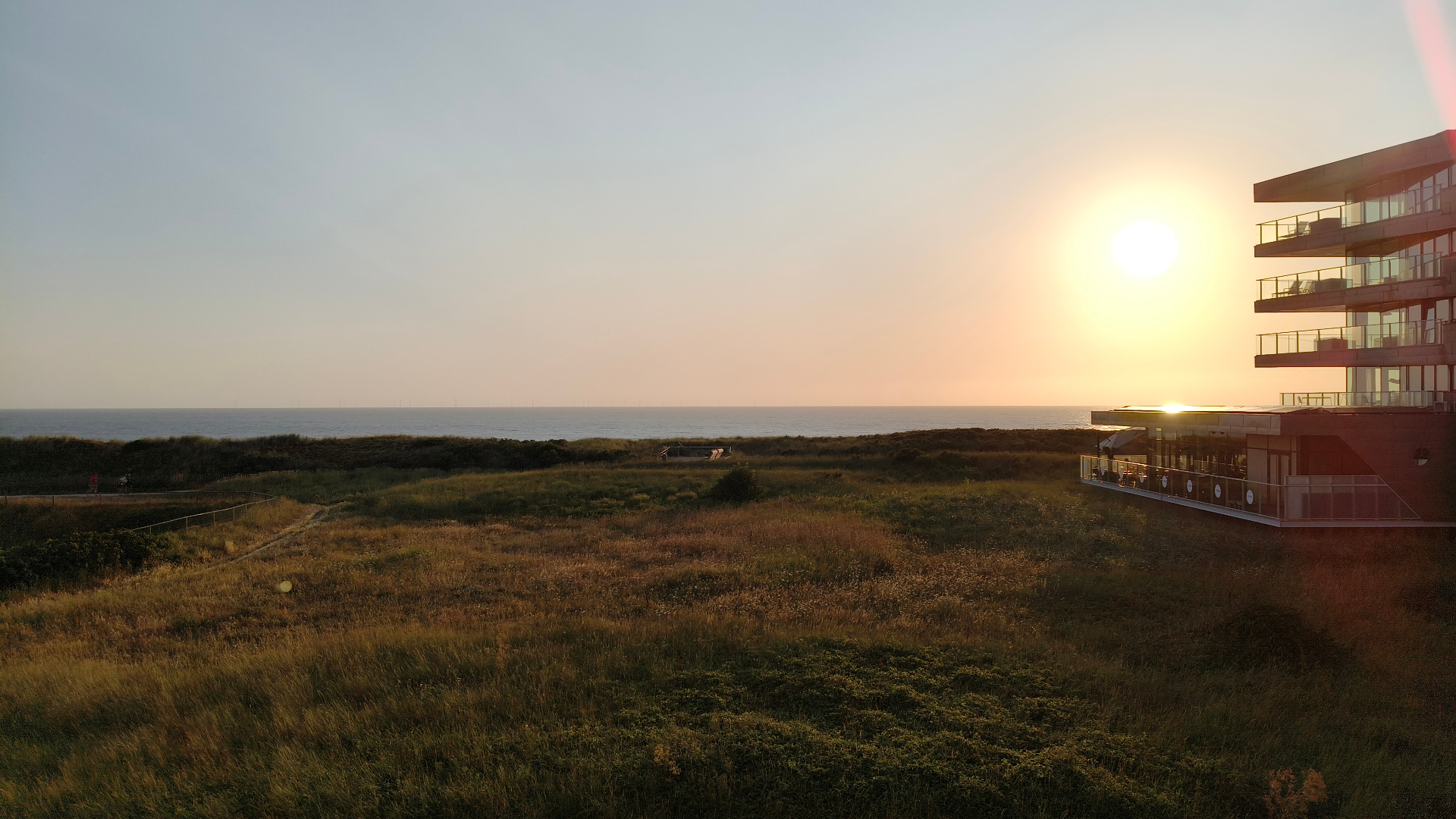 Zonsondergang boven de duinen en zee
